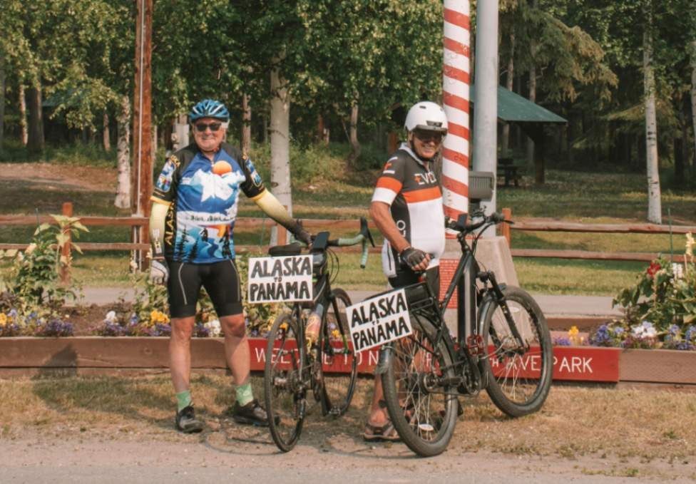 Two men holding eMTBs at the start of a long distance ride